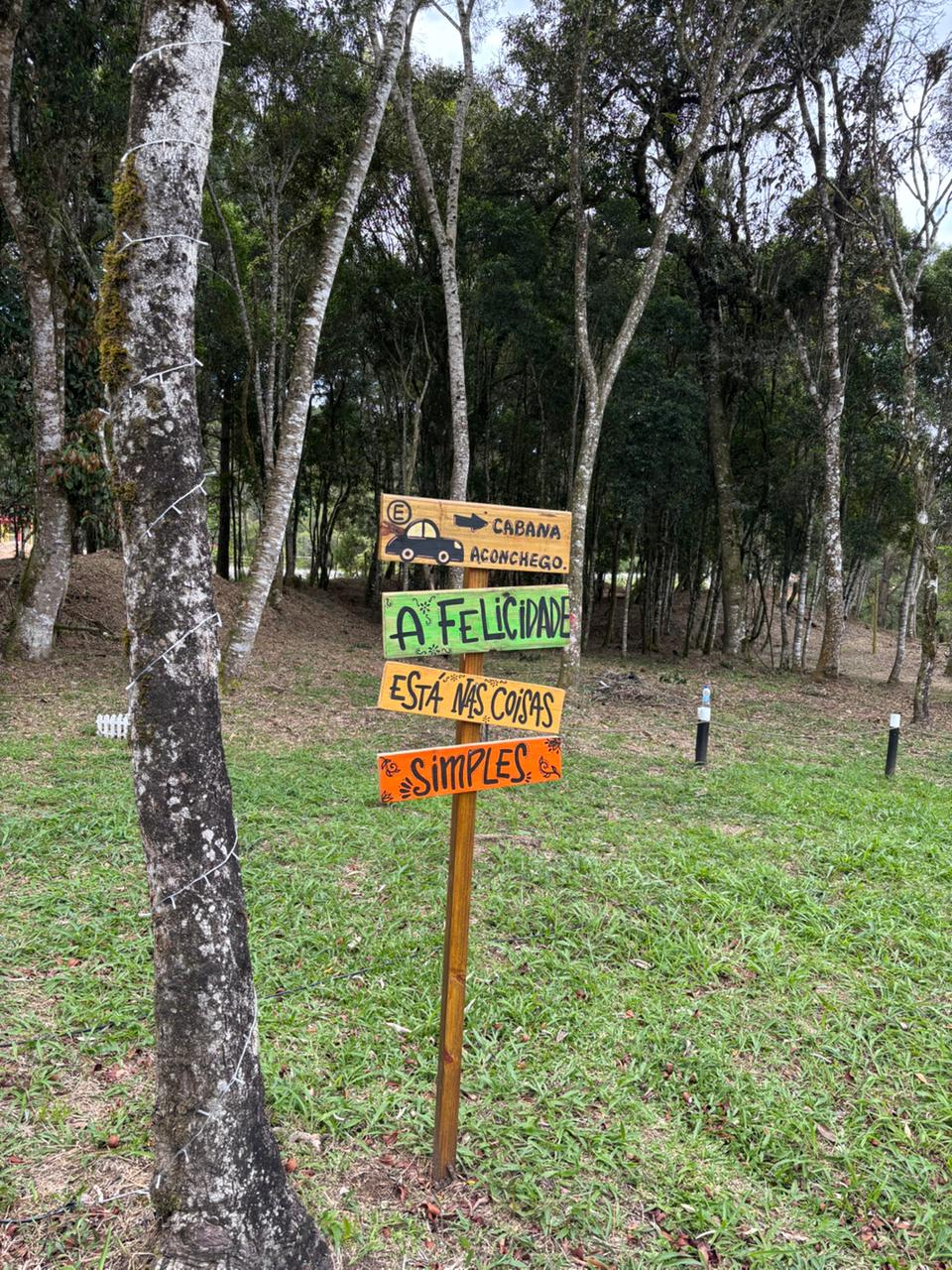 Placas de madeira indicando a Cabana Aconchego